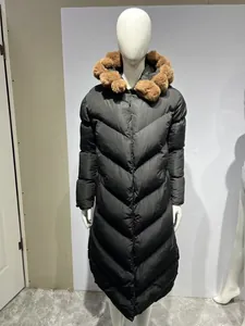 Long black quilted puffer coat featuring a brown faux fur collar shown on a mannequin