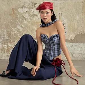Asian model wearing a blue plaid denim corset and wide-leg pants with a red flower detail.