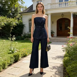 Full body shot of a model wearing a dark blue strapless denim set in a garden setting