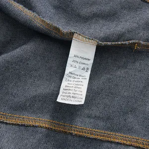 Detail view of denim garment care label showing 80% polyester and 20% cotton material