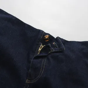 Close-up detail view showing the metal zipper and golden button on dark blue denim