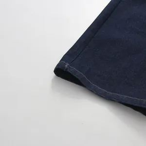 High-quality detailed close-up of dark blue denim hem with contrast yellow stitching