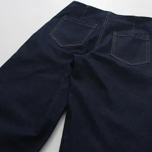 Close-up of functional back pockets on dark blue high-waisted wide-leg denim jeans