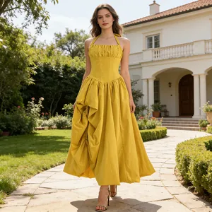 Detailed view of elegant mustard yellow halter dress with corset waist and tiered skirt.