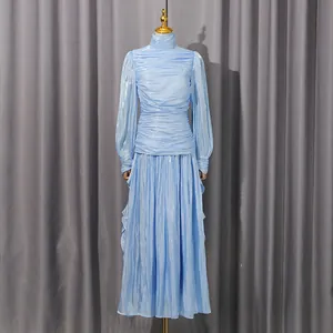 Detalle de un vestido largo plisado azul claro de estilo francés con manga larga