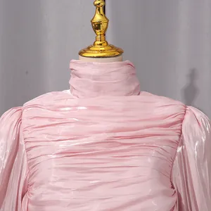 Vista detallada de un elegante vestido plisado rosa con cuello alto y tejido brillante