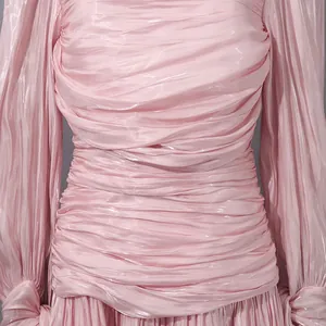 Primer plano de los elegantes detalles fruncidos rosas de un vestido de manga larga