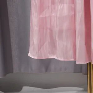 Detalle macro de la delicada textura plisada y el dobladillo de un vestido rosa de estilo francés