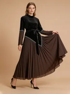 Elegant long-sleeved pleated dress featuring a black velvet bodice and brown skirt
