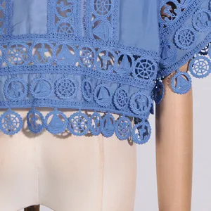 Detailaufnahme einer hellblauen Spitzenbluse mit Stickereien im nautischen Thema