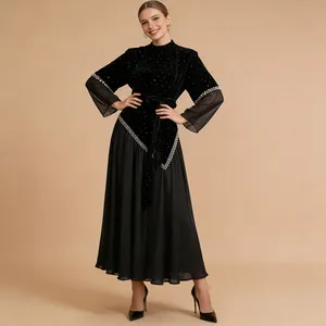 Elegant black velvet and mesh dress with pearl embellishments and pleated skirt.