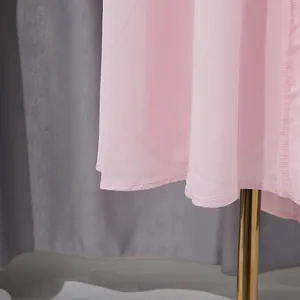 Detalle macro del dobladillo y las costuras finas en un vestido largo plisado rosa de estilo francés