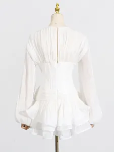 Achteraanzicht van elegante witte mini-jurk met ruches en korset in de taille