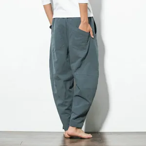 Back view showing the loose fit of men's teal harem pants in cotton linen fabric