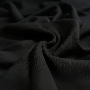 Macro detail view of high-quality black ribbed knit fabric texture on a bandage dress