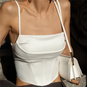 Dettaglio di un top a corsetto in raso bianco con pieghe eleganti e struttura definita
