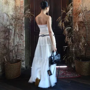 Vue arrière d'un ensemble jupe longue à volants chic et haut bandeau blanc, décor rustique