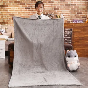 Soft grey faux rabbit fur plush blanket being held by a model for size demonstration