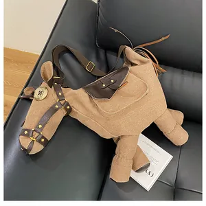 Unique donkey shaped canvas crossbody bag displayed artistically on a black leather couch