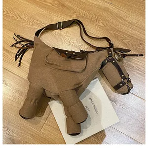 Artistic donkey-shaped canvas crossbody bag with whimsical design shown on wooden floor.