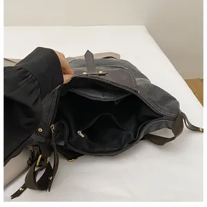 Detail view of the spacious interior compartments and zipper pocket of the canvas bag