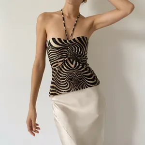 Elegant zebra print halter neck backless top with pleated details worn by a model
