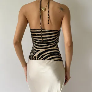 Back view of a zebra print sequin halter top with backless design and satin skirt