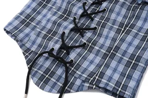 Close-up view showing the black lace-up detail and metal eyelets on a blue plaid corset top