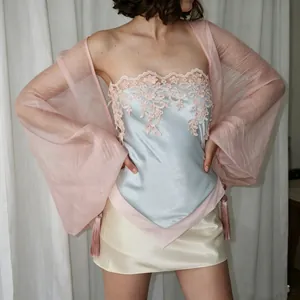 Detalle del top bandeau de satén azul claro con encaje rosa y dobladillo irregular.
