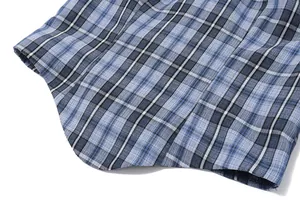 Macro detail shot of blue plaid denim tube top fabric texture and curved hemline
