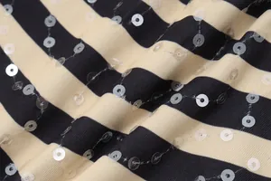 Close-up detail of striped fabric with shimmering transparent sequin embellishments