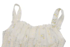 Gros plan du haut à fleurs avec bretelles volantées et détails de bustier smocké.