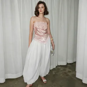 Elegante top de satén rosa con delicado encaje floral y un bajo asimétrico irregular