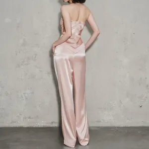 Vista trasera de un conjunto de dos piezas de satén rosa con top y pantalón.