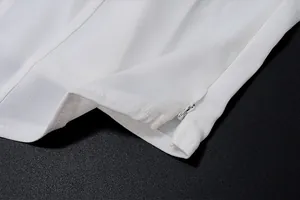 Dettaglio della cerniera invisibile e del tessuto di raso bianco lucido e liscio