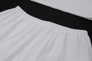 Détail rapproché d'un ensemble blanc deux pièces avec taille élastique et tissu texturé