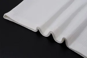 Gros plan sur le détail du tissu côtelé blanc montrant la texture de couture