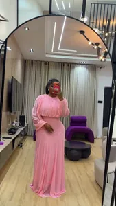 Elegante completo rosa con top a maniche a sbuffo e gonna lunga a vita alta allo specchio.