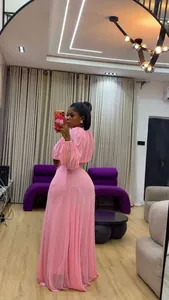 Vista intera di una modella che indossa un completo rosa con camicetta e gonna lunga