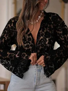 Detailed macro shot of an elegant black floral hollow lace blouse with flared sleeves