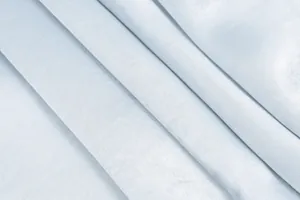 Vista macro que muestra la textura suave y los pliegues elegantes de la tela de raso azul claro