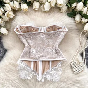 Close-up of white floral lace corset top with delicate eyelash trim on faux fur background