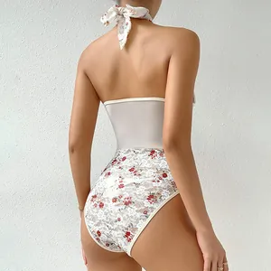 Dettaglio di un body all'americana in pizzo floreale con inserti in rete sulla vita.