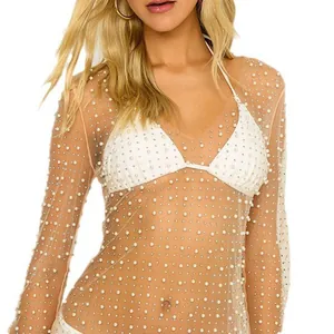 Dettaglio copricostume in mesh trasparente con perle e strass su maniche lunghe