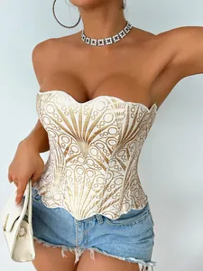 Dettaglio di un corsetto con paillettes bianche e oro con eleganti motivi decorativi