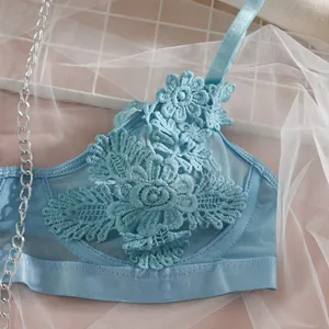Détail d'une lingerie en dentelle bleue avec broderie florale délicate et maille filet.