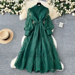 Détail d'une robe longue française en dentelle vert foncé avec broderies et manches bouffantes chic