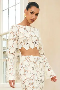 Close-up of elegant white floral lace two-piece set featuring long sleeves and mermaid skirt