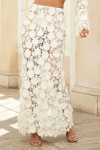 Close-up detail of cream 3D floral lace fabric on elegant French style fish-tail maxi skirt