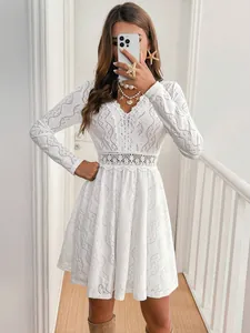 Detail view of elegant white lace mini dress with V-neck and scalloped hemline